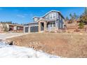 Two-story house with gray siding, two-car garage, and a landscaped yard at 4285 Mohawk Dr, Larkspur, CO 80118