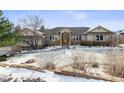 Front of a two-story home with a landscaped yard and snow-dusted bushes at 16730 Golden Hills Rd, Golden, CO 80401