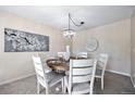 Charming dining room with a round wooden table and white chairs at 17806 E Carolina Pl, Aurora, CO 80017