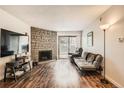 Living room with stone fireplace and hardwood floors at 445 Wright St # 111, Lakewood, CO 80228