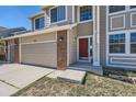 Front view of house with tan siding and two car garage at 513 Hampstead Ave, Castle Rock, CO 80104