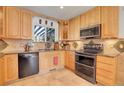 Bright kitchen featuring wood cabinets, granite countertops, and stainless steel appliances at 1618 S Kenton St, Aurora, CO 80012