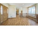 Bright entryway with hardwood floors, staircase, and view of kitchen at 2203 S County Road 185, Byers, CO 80103