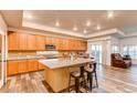 Spacious kitchen with granite island and light wood cabinets at 10303 Pitkin Ct, Commerce City, CO 80022