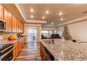 Kitchen with granite countertops, wood cabinets, and sliding door to patio at 10303 Pitkin Ct, Commerce City, CO 80022