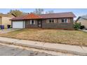 Ranch style home with a two-car garage and neat lawn at 14830 Robins Dr, Denver, CO 80239