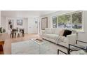 Bright living room featuring hardwood floors, a comfy sofa, and large windows at 34 University Dr, Longmont, CO 80503