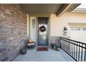 Inviting front entry with stone accents and a seasonal wreath at 2453 Reserve St, Erie, CO 80516