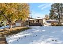 Landscaped yard with mature trees and light snow cover at 824 W Geddes Cir, Littleton, CO 80120