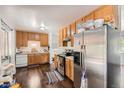 Kitchen with wood cabinets and stainless steel refrigerator at 606 Elkhart St, Aurora, CO 80011