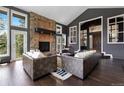 Living room with a stone fireplace, hardwood floors, and high ceilings at 20390 Brookmont Rd, Morrison, CO 80465