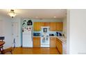 View of kitchen with wood cabinets, appliances, and laminate flooring at 762 Mockingbird Ln, Brighton, CO 80601