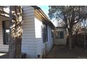 White sided home with mature trees and a partially visible deck at 1964 Galena St, Aurora, CO 80010