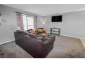Living room with dark leather sofas, a coffee table, and a TV at 18971 E Mercer Dr, Aurora, CO 80013