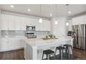 Modern kitchen with white cabinets, quartz countertops, and stainless steel appliances at 8885 S Tibet Ct, Aurora, CO 80016