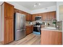 Modern kitchen with stainless steel appliances and wood cabinets at 8457 Thunder Ridge Way # 103, Highlands Ranch, CO 80126