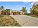 Cute ranch home with a long driveway, covered porch, and spacious backyard at 2215 S Knox Ct, Denver, CO 80219