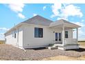White exterior home with covered back porch and landscaping at 42962 Colonial Trl, Elizabeth, CO 80107