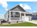 Two-story craftsman style home with gray and white exterior, stone accents, and a two-car garage at 42962 Colonial Trl, Elizabeth, CO 80107