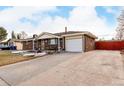 Front view of home with driveway and fenced yard at 12660 E Alaska Pl, Aurora, CO 80012