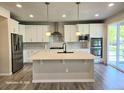 Modern kitchen with large island, stainless steel appliances, and white cabinets at 23895 E Rocky Top Pl, Aurora, CO 80016