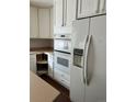Kitchen with white cabinets, double oven, and refrigerator at 21476 E 53Rd Pl, Denver, CO 80249