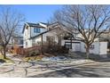 Two-story house with white siding, black accents, and a fenced backyard at 15386 E 101St Pl, Commerce City, CO 80022