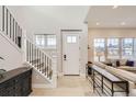 Bright and spacious entryway with staircase and light wood floors at 10302 E 63Rd Ave, Denver, CO 80238