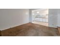 Living room with kitchen view, brown carpet, and white walls at 13657 E Yale Ave # A, Aurora, CO 80014
