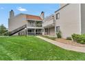 Tan multi-unit building with grassy area and walkway at 13657 E Yale Ave # A, Aurora, CO 80014