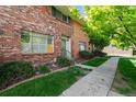Brick townhome exterior showcasing front entrance and landscaping at 9079 E Nassau Ave, Denver, CO 80237