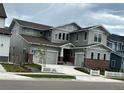 Two-story craftsman style home with gray siding, white picket fence, and two-car garage at 1834 Chestnut Ave, Erie, CO 80516