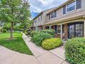 Townhouse exterior with landscaping, walkway, and brick facade at 8750 E Yale Ave # B, Denver, CO 80231