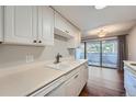 Kitchen with white cabinets, double sink and dishwasher at 6420 S Dayton St # J06, Englewood, CO 80111