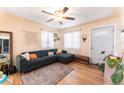 Living room with L-shaped sofa, hardwood floors, and a ceiling fan at 262 S Bryant St, Denver, CO 80219