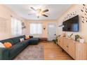 Living room with L-shaped sofa, hardwood floors, and a mounted TV at 262 S Bryant St, Denver, CO 80219