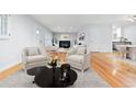 Open concept living room with hardwood floors and fireplace at 3565 S Holly St, Denver, CO 80237