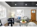 Bright living room features gray sofa, unique coffee table and two armchairs at 1698 S Garfield St, Denver, CO 80210