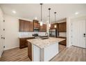 Modern kitchen with island and stainless steel appliances at 6153 N Ceylon St # 205, Denver, CO 80249