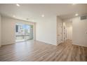 Living room with sliding door to balcony and laminate flooring at 6153 N Ceylon St # 205, Denver, CO 80249