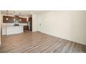 Open living room and kitchen area with laminate floors at 6153 N Ceylon St # 205, Denver, CO 80249