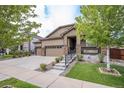 House exterior with a two-car garage, front porch, and landscaping at 41 S Jackson Gap Way, Aurora, CO 80018