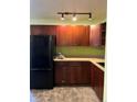 Kitchen with dark wood cabinets, tile backsplash, and black appliances at 2213 S Kingston Ct, Aurora, CO 80014