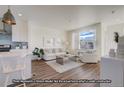 Bright and airy living room with white sofas and large windows at 2672 W 68Th Ave, Denver, CO 80221