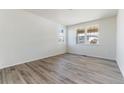 Bright and airy living room with wood-look floors at 3180 Boral Owl Dr, Brighton, CO 80601