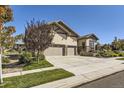 Two-story house with a three-car garage and mature trees in the front yard at 15688 Deer Mountain Cir, Broomfield, CO 80023