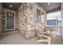 Inviting front porch with stone facade and comfortable seating at 4983 Trails Edge Ln, Castle Rock, CO 80104