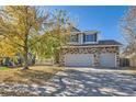 Two-story home with stone accents, three-car garage, and autumn leaves at 5504 E Burlington Dr, Castle Rock, CO 80104