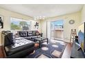 Spacious living room with leather sectional and access to a balcony at 10211 Ura Ln # 8-207, Thornton, CO 80260