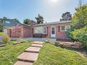 Brick ranch home with a stone walkway and mature trees at 3540 E Arapahoe Pl, Centennial, CO 80122